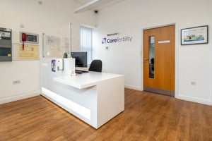 Welcome desk at Care Fertility Cheshire, Warrington, with “Welcome to Care Fertility” wall signage — professional and friendly clinic reception.