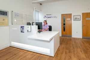 Reception desk at Care Fertility with a friendly staff member ready to welcome patients.