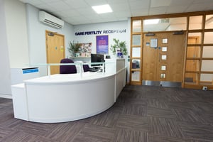 Upstairs welcome desk at Care Fertility Nottingham, with “Care Fertility Reception” wall signage — professional and friendly clinic reception.