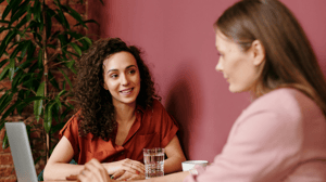 Two women chatting warmly during a fertility consultation, highlighting open, compassionate support.