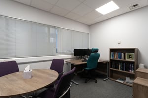 Private consultation room at Care Fertility Leeds with desk, seating area and soft neutral décor.