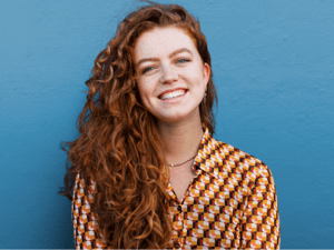 Single woman with red hair smiling.