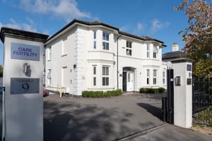 Exterior of Care Fertility Tunbridge Wells, a white period building with a Care Fertility sign at the entrance gate