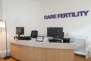 Reception desk at Care Fertility Tunbridge Wells with the Care Fertility logo on the wall
