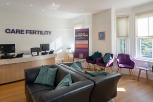 Waiting room at Care Fertility Tunbridge Wells with leather sofas, purple armchairs, and the reception desk
