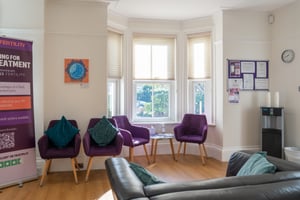 Waiting area by a bay window at Care Fertility Tunbridge Wells with purple armchairs
