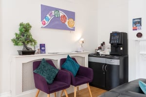 Refreshment area at Care Fertility Tunbridge Wells with a coffee machine and purple armchairs