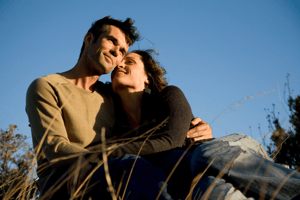 Middle aged couple sat in grass