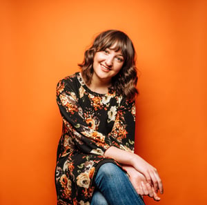Brunette woman against orange background