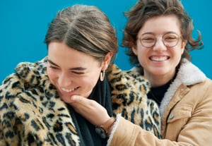 Same-sex couple smiling and laughing outdoors, representing inclusive fertility care for everyone.